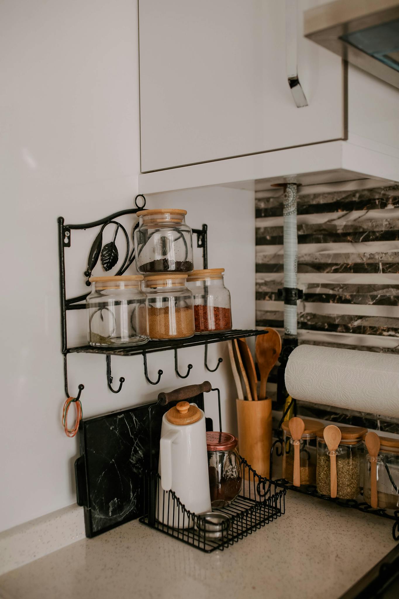 Stylish kitchen corner with spice jars and utensils on display.